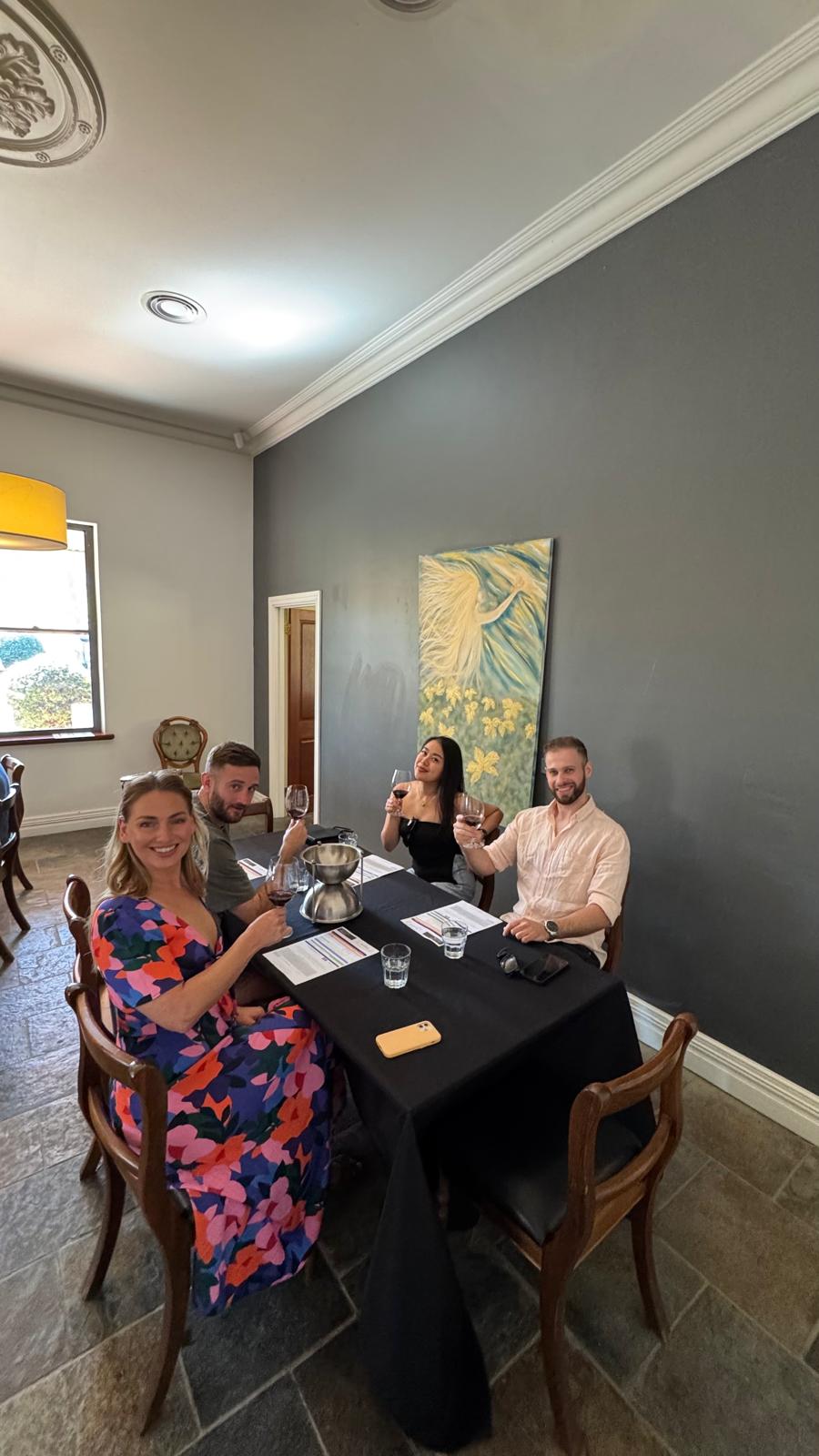 Guests gathered at the tasting bar during a wine tasting under a thatched cellar door roof