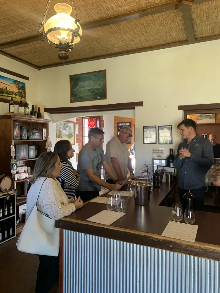 Guests sampling wines at the cellar door bar with their host